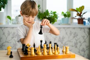 The little boy plays chess, back to school, a strategy game to develop mental abilities